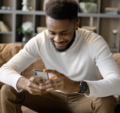 A man with his phone texting with a smiley face